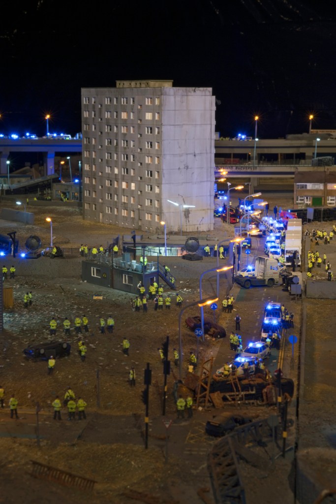NLD, Niederlande, Eindhoven, Ausstellung bei Piet Hein Eek: THE AFTERMATH DISLOCATION PRINCIPLE Part IV von James Cauty 2014. “Once he burned a million quid, reached number one on the charts and made a posting stamp with the Queen wearing a gas mask printed on it. Now the British ‘culture terrorist’ James Cauty works quietly on his dioramas of rioters and battering policemen.” | NLD The Netherlands, Eindhoven, exhibition at Piet Hein Eek: THE AFTERMATH DISLOCATION PRINCIPLE Part IV by James Cauty 2014. “Once he burned a million quid, reached number one on the charts and made a posting stamp with the Queen wearing a gas mask printed on it. Now the British ‘culture terrorist’ James Cauty works quietly on his dioramas of rioters and battering policemen.”