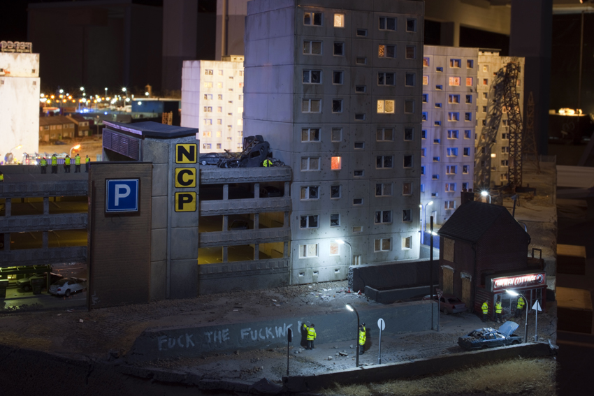 NLD, Niederlande, Eindhoven, Ausstellung bei Piet Hein Eek: THE AFTERMATH DISLOCATION PRINCIPLE Part IV von James Cauty 2014. “Once he burned a million quid, reached number one on the charts and made a posting stamp with the Queen wearing a gas mask printed on it. Now the British ‘culture terrorist’ James Cauty works quietly on his dioramas of rioters and battering policemen.” | NLD The Netherlands, Eindhoven, exhibition at Piet Hein Eek: THE AFTERMATH DISLOCATION PRINCIPLE Part IV by James Cauty 2014. “Once he burned a million quid, reached number one on the charts and made a posting stamp with the Queen wearing a gas mask printed on it. Now the British ‘culture terrorist’ James Cauty works quietly on his dioramas of rioters and battering policemen.”